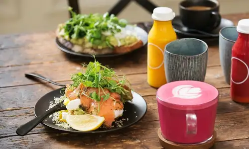 Indulge in a gourmet breakfast with fresh juices and a vibrant latte.