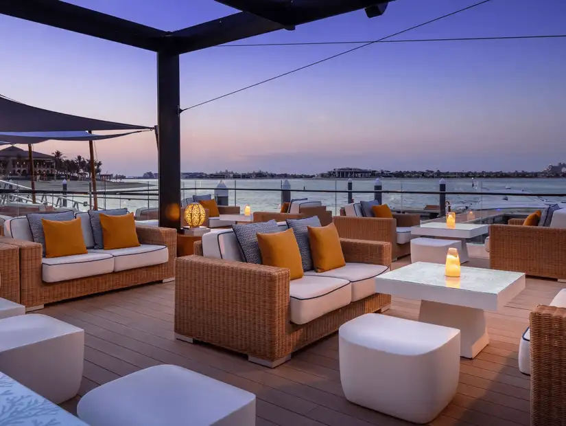 Cozy outdoor lounge with a stunning sunset view over the water.