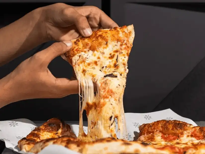 A tantalizing display of cheese pizza with a perfect cheese pull, showcasing the gooey and deliciously melted cheese.