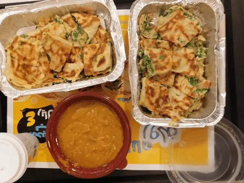 Hearty platter of cut stuffed bread and a bowl of lentil soup.