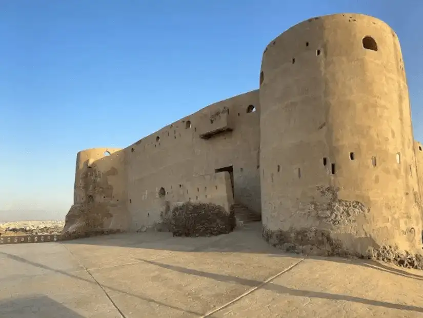 The imposing earthen walls of an ancient fortress standing under the clear sky, echoing stories of the past.