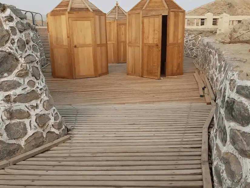 Rustic wooden changing huts on a deck path, offering a blend of beachside convenience and natural scenery.