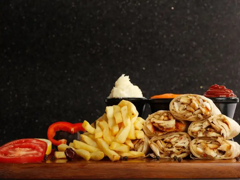 A delicious shawarma platter with fries and condiments.