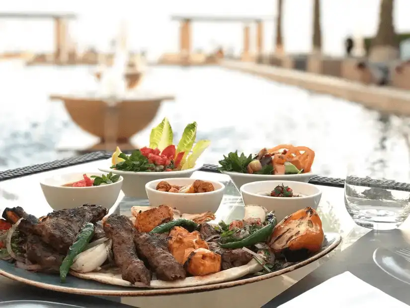 Grilled meats and seafood served poolside with fresh salads and dips.