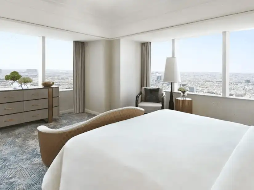 Hotel room with a modern aesthetic and a panoramic city view.