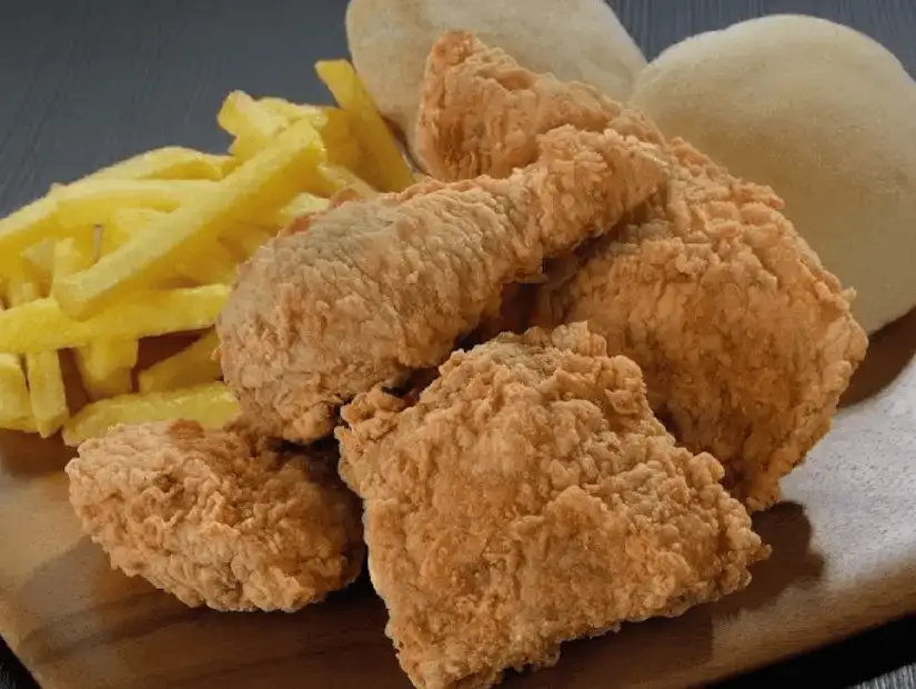 Classic comfort food featuring crispy fried chicken with fries and soft bread.