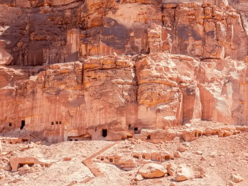 Ancient tombs embedded in the towering sandstone cliffs.