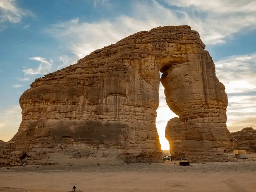 1.	A silhouette of a grand rock formation against a setting sun in AlUla.