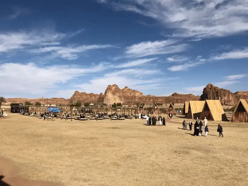 Visitors explore the vast open area surrounded by AlUla's geological marvels.