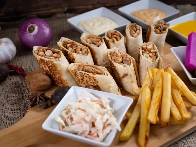 Shawarma wraps served with fries and dipping sauces.