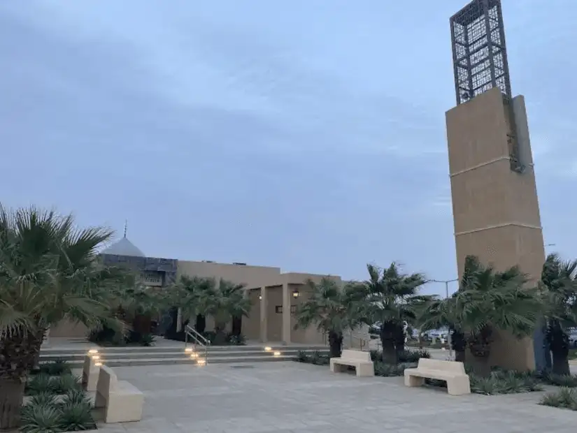 Serene early evening at a park with minimalist architecture and a towering minaret, creating a contemplative ambiance.