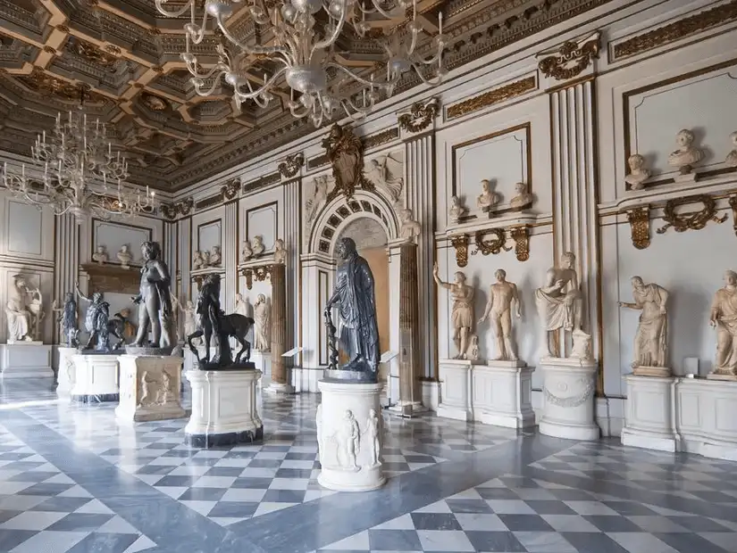 A grand interior hall of the Capitoline Museums, showcasing classical statues and ornate ceilings.