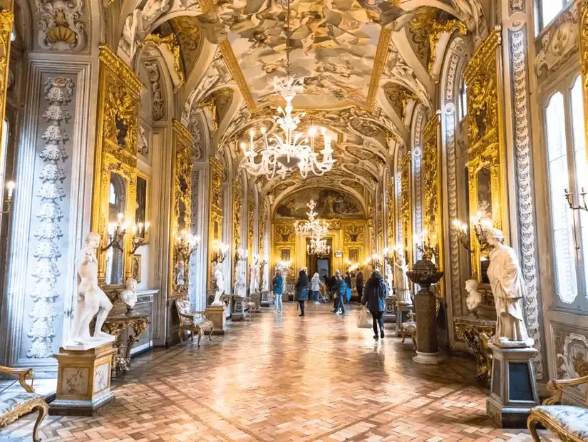 The opulent gallery of Palazzo Doria Pamphili, adorned with gold and magnificent chandeliers.