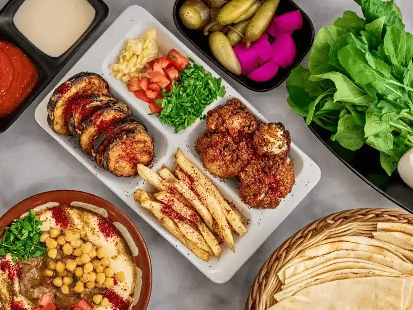 Middle Eastern feast with falafel, hummus, and seasoned fries.