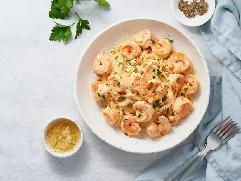 Creamy pasta with plump shrimp, garnished with parsley for an elegant touch.