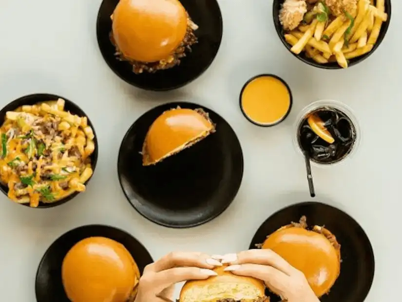 An overhead view of a meal with multiple burgers and fries, capturing a feast ready to be enjoyed.