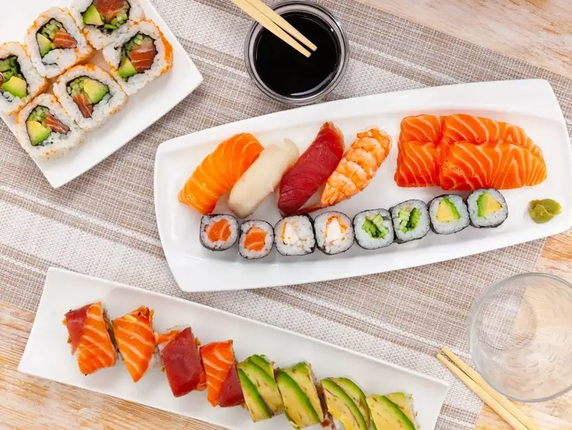 Elegant salmon nigiri sushi arranged with fresh parsley.