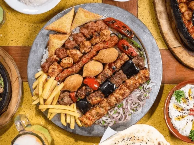 Mixed grill platter with kebabs, falafel, and fries – a feast for meat lovers.