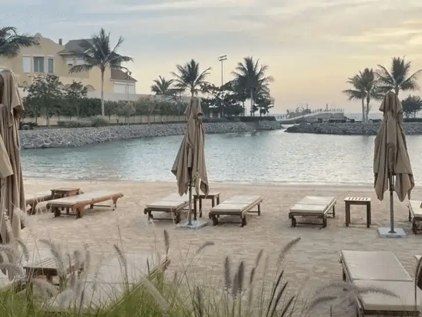 Empty beach chairs on a sandy shore in the gentle embrace of dusk.