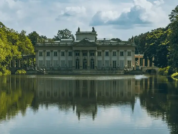 The serene Palace on the Isle in Lazienki Park, reflecting gracefully in the calm waters of the surrounding lake.