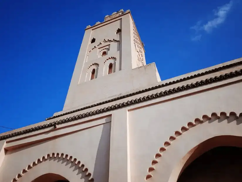 A close-up of a traditional minaret against a clear blue sky.