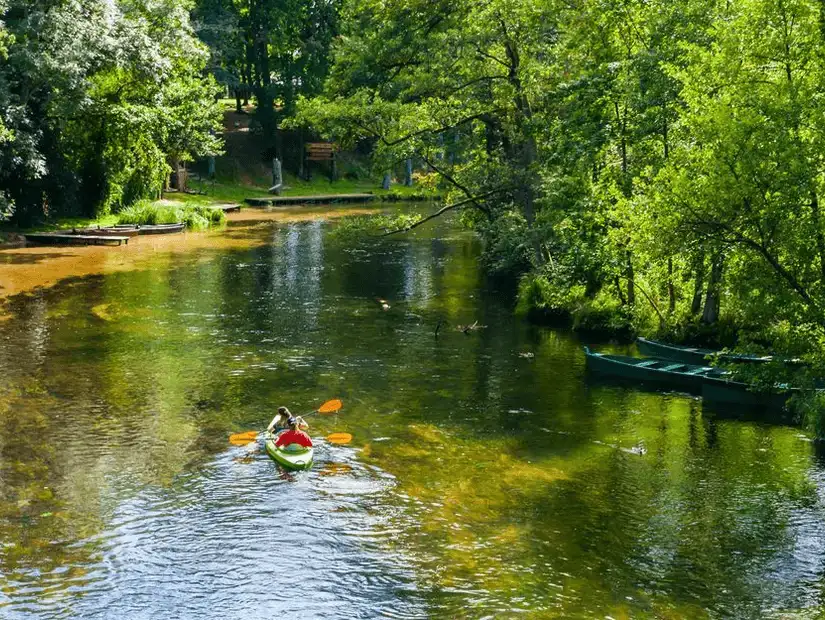 A serene kayak ride through the lush greenery and calm waters of Mazury Park, a peaceful natural retreat.