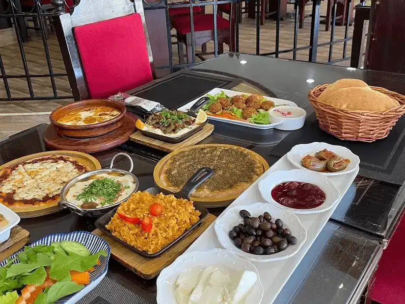 A spread of Middle Eastern cuisine featuring a variety of dips, bread, and cooked dishes.