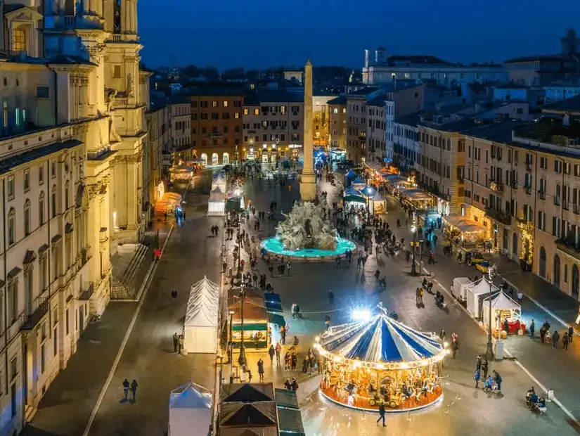 A lively night at Piazza Navona, with a bustling market and a glowing carousel.