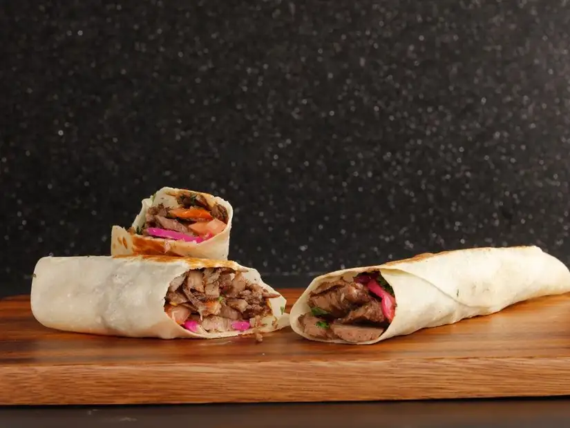 Savory shawarma wraps on a wooden board.