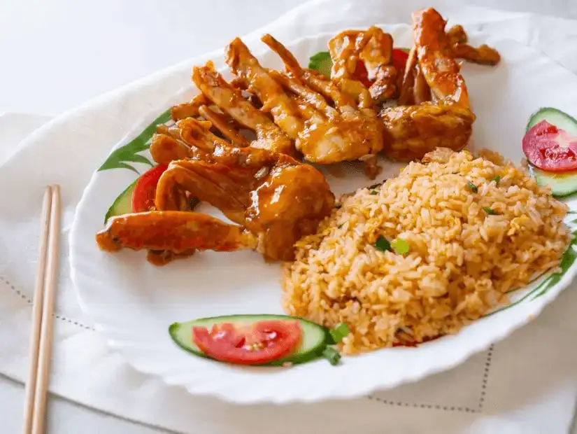 Spicy glazed chicken wings paired with aromatic fried rice and fresh vegetables.