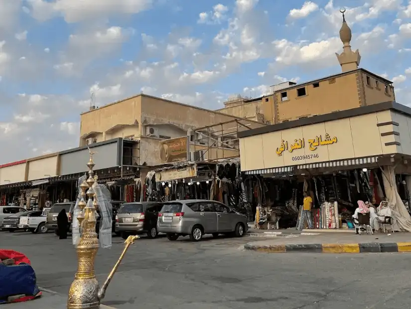 Traditional marketplace with a large ornate teapot sculpture in the foreground.