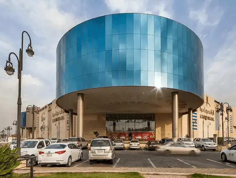 The modern and sleek exterior of Rashid Mega Mall, with a striking blue cylindrical entrance.