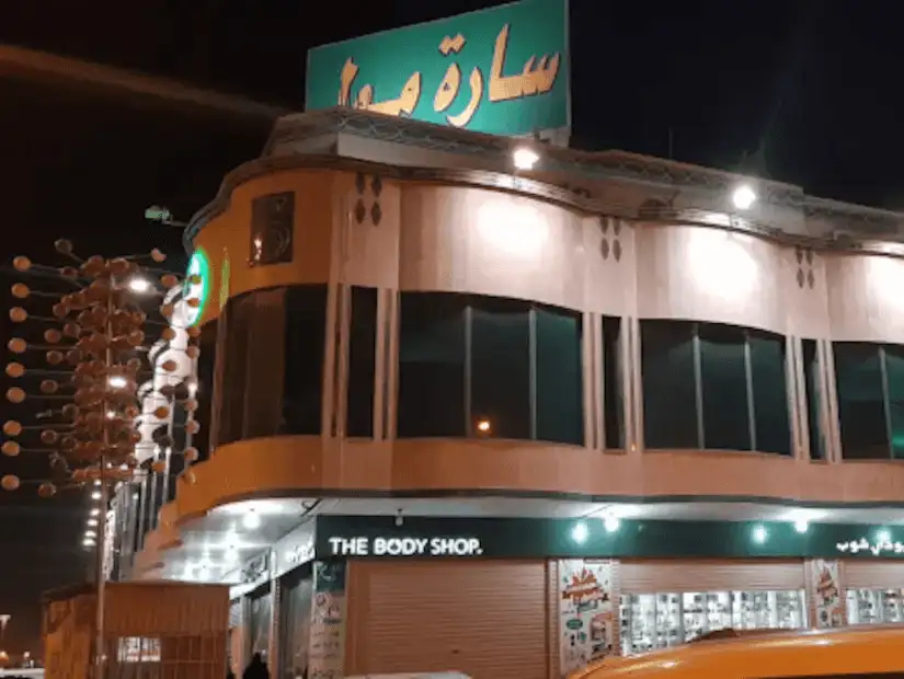 Night view of Sarah Mall's facade with bright signage and urban surroundings.