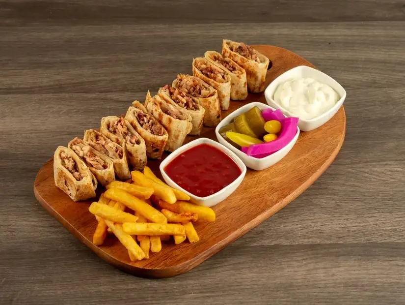 Shawarma wraps served with fries and pickles.