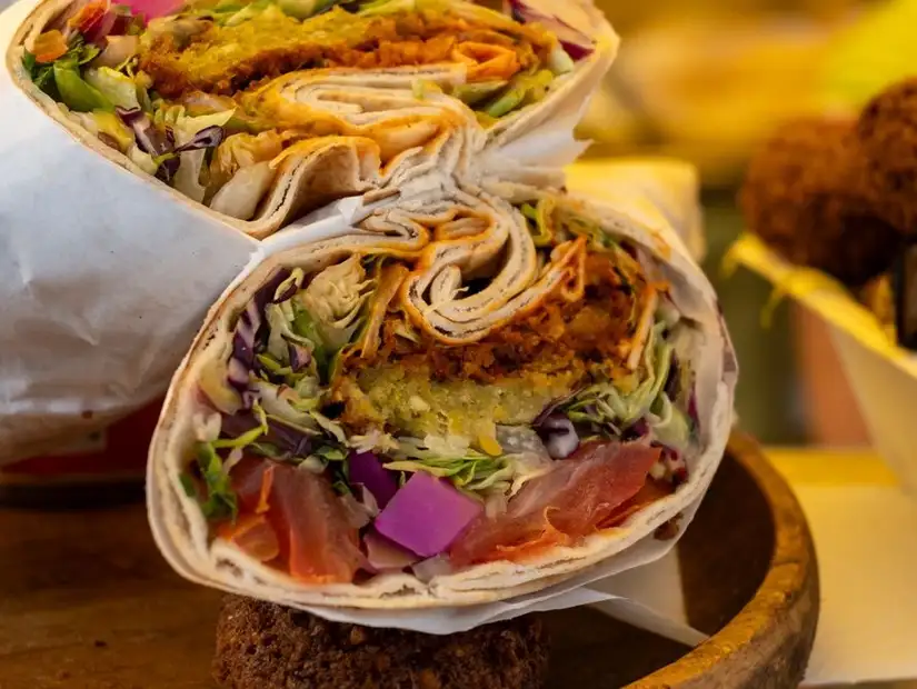 A vibrant falafel wrap packed with fresh vegetables.