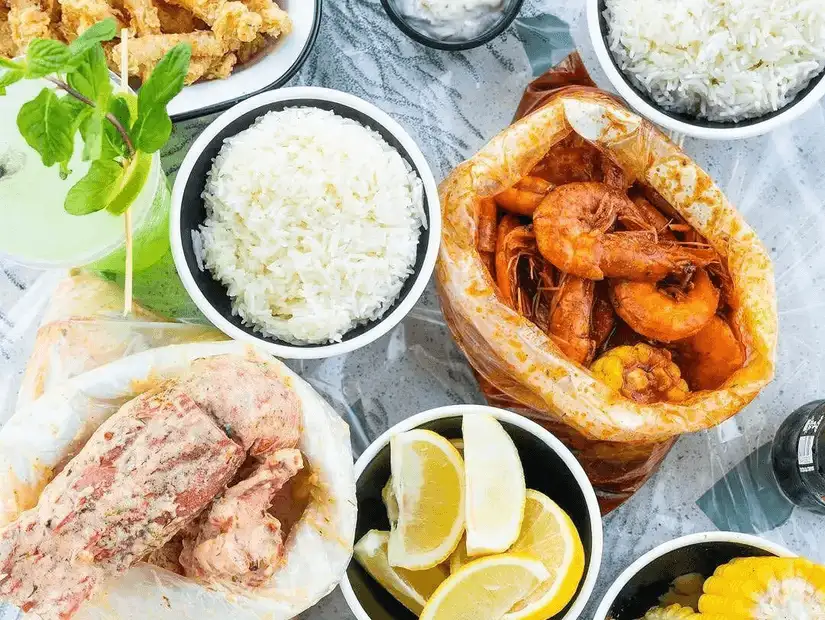 A medley of seafood and sides: succulent shrimps, fried fish, lemon slices, and creamy dips.