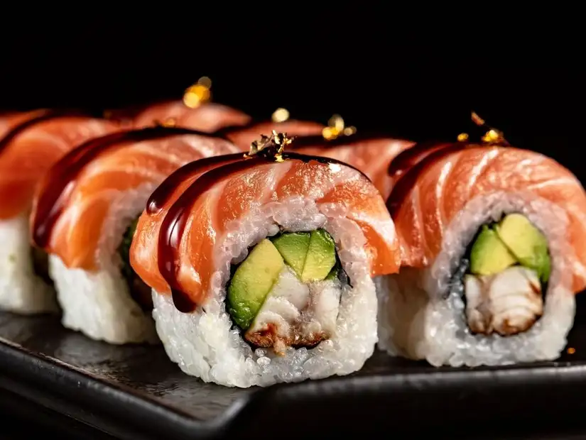 Classic salmon and avocado sushi rolls with vibrant garnishes.