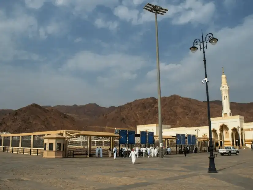 Uhud Cemetery, with visitors paying their respects amidst the tranquil surroundings of Mount Uhud.