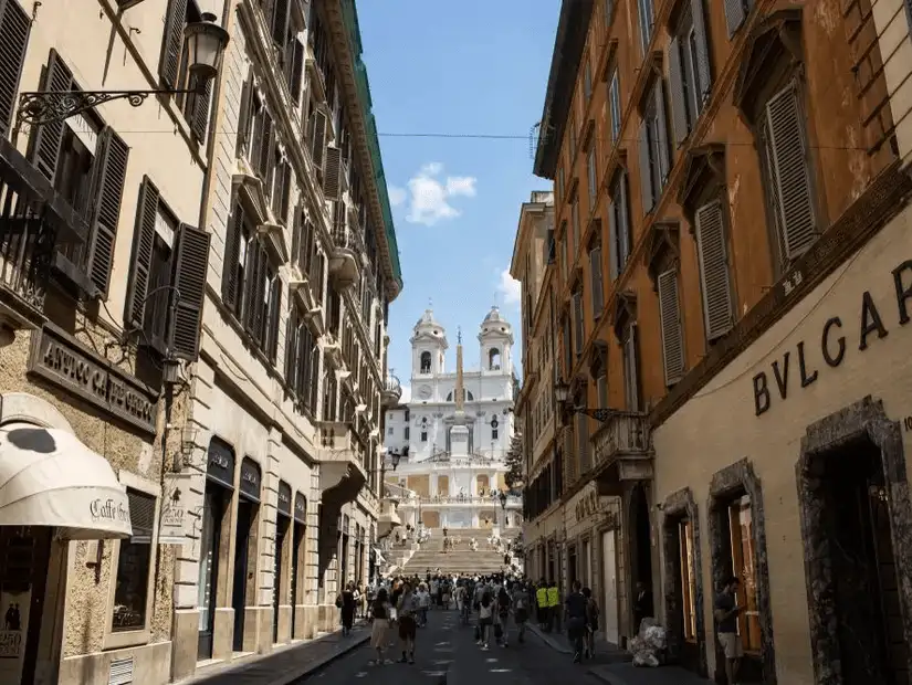 A bustling Via Condotti leading to the iconic Spanish Steps, surrounded by elegant boutiques.