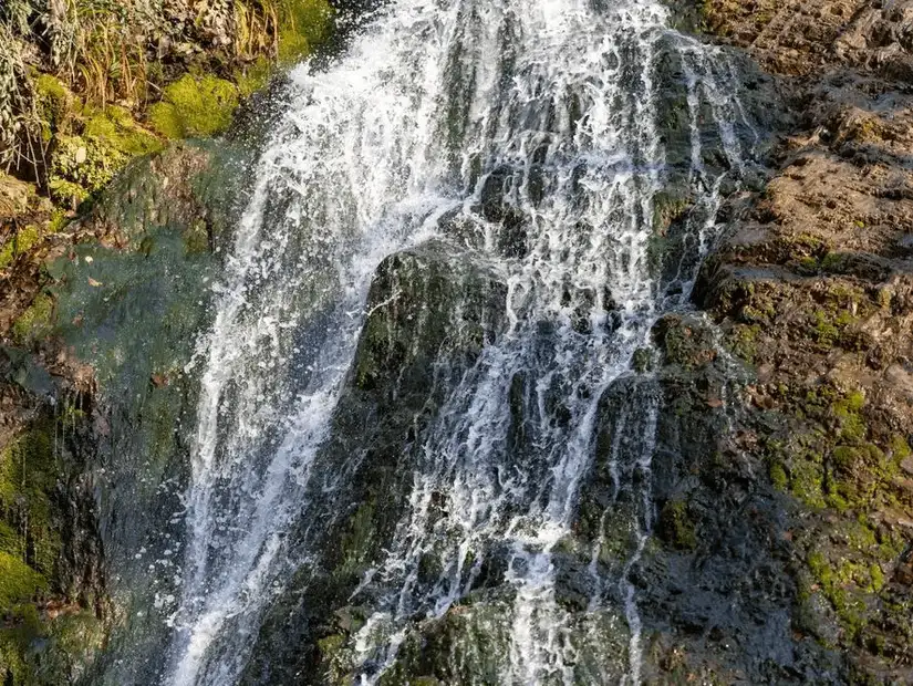 The cascading waters of Yedi Gozel Waterfall surrounded by lush greenery.