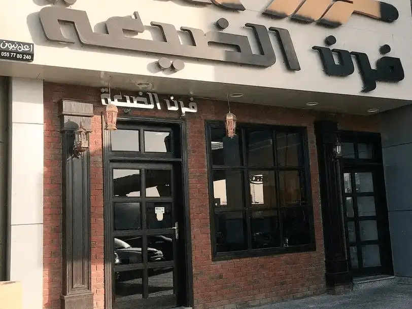 Entrance of a traditional restaurant featuring Arabic calligraphy and brick façade.