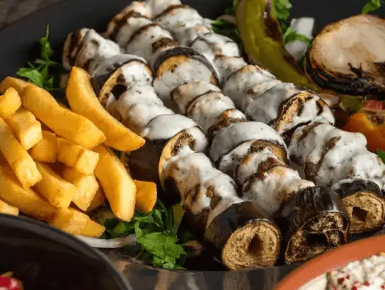 Grilled mushroom skewers served with fries and a creamy dip.