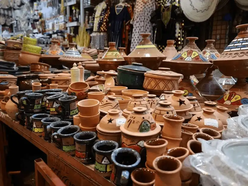 Clay pots and kitchenware displayed in a traditional market.