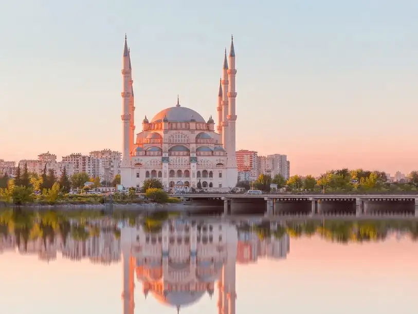 Sabancı Central Mosque reflected in the Seyhan River at sunset in Adana.