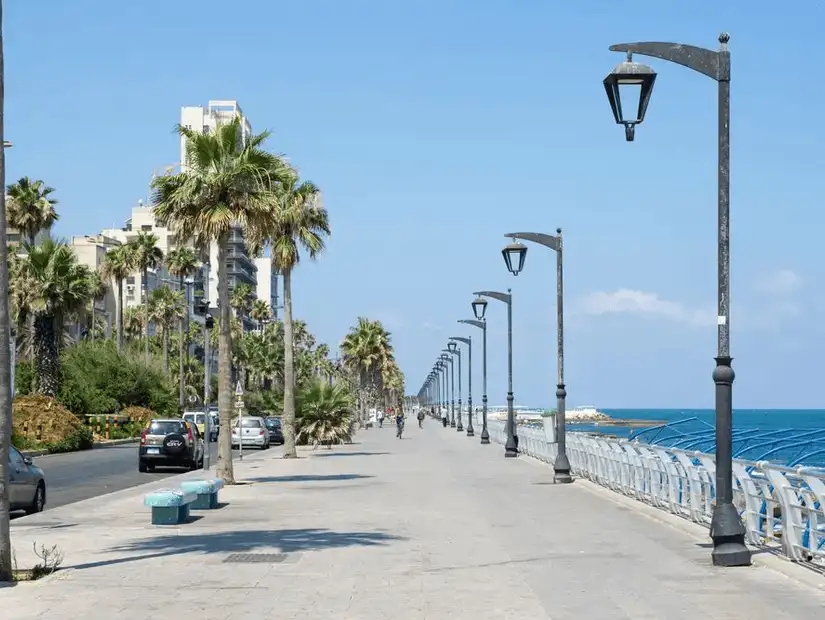 The scenic Ain El Mreisseh Corniche, a peaceful seaside promenade lined with palm trees and street lamps.