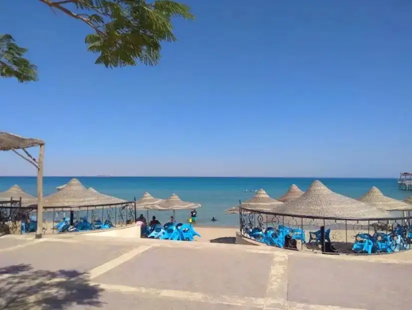 A beach in Ain Sokhna featuring umbrellas and beach chairs along with a peaceful sea view.