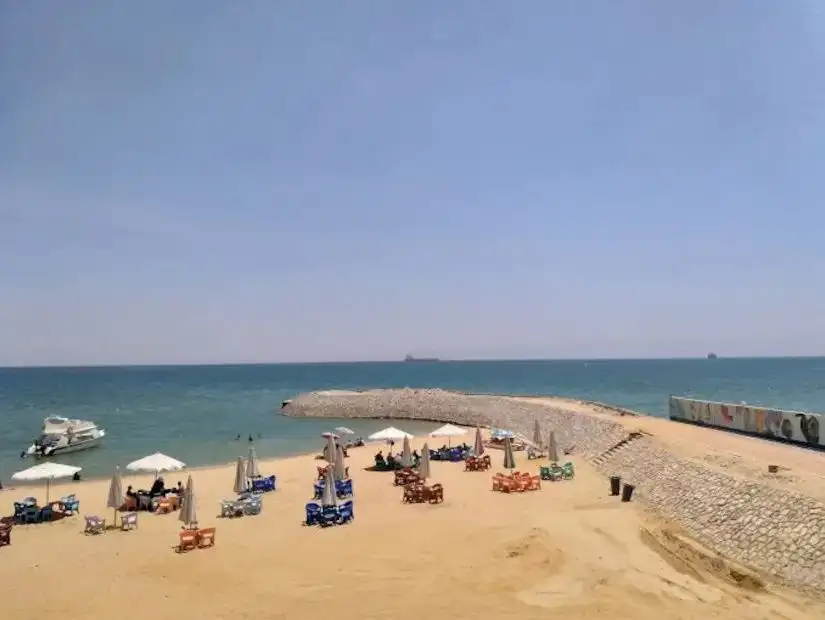 A close-up of a beach umbrella with a beautiful view of the Ain Sokhna beach and ocean.