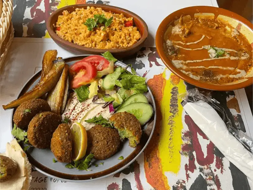 A sizzling plate of spiced minced meat with fresh chilies and herbs, served with flatbread.