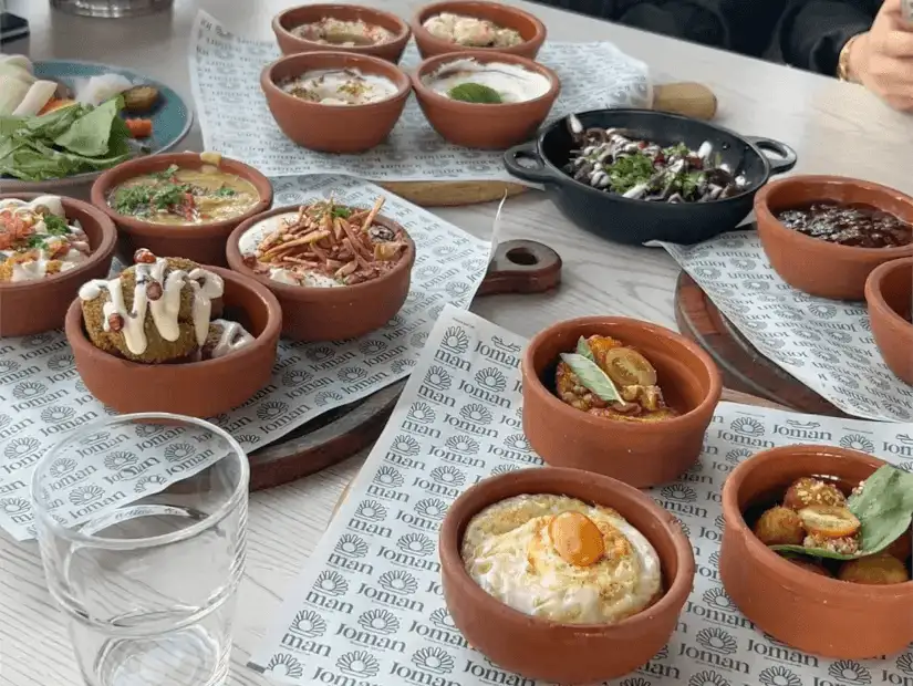 A mixed brunch featuring cheesy pide, creamy dips, and refreshing juices.