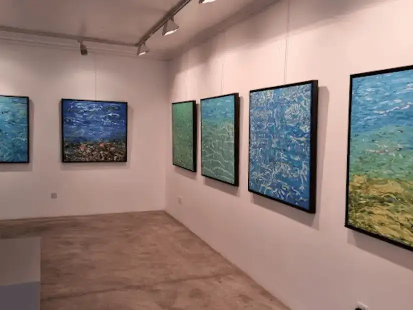 An elegant art exhibition at Albareh Art Gallery, featuring a collection of abstract underwater-themed paintings.